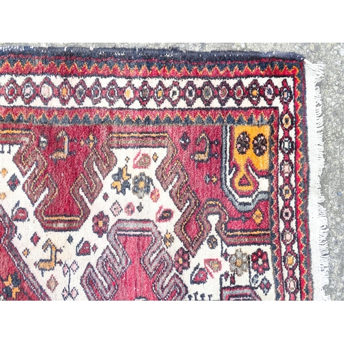 1344 - Carpet / Rug : A rug with red and cream ground decorated with geometric motifs and stylised birds an... 