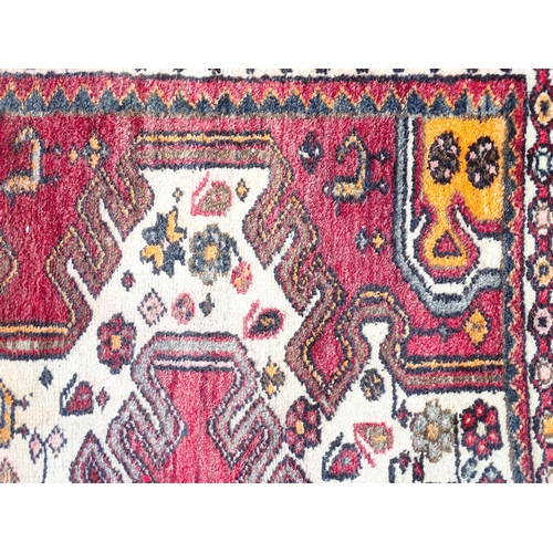 1344 - Carpet / Rug : A rug with red and cream ground decorated with geometric motifs and stylised birds an... 