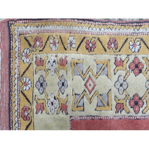 1345 - Carpet / Rug : A rug with salmon and cream grounds with geometric and floral detail and mustard bord... 