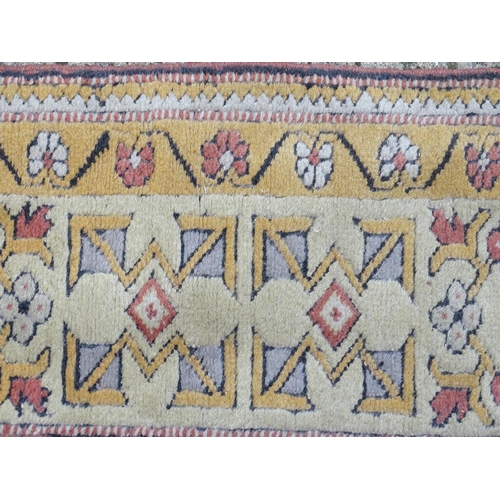 1345 - Carpet / Rug : A rug with salmon and cream grounds with geometric and floral detail and mustard bord... 