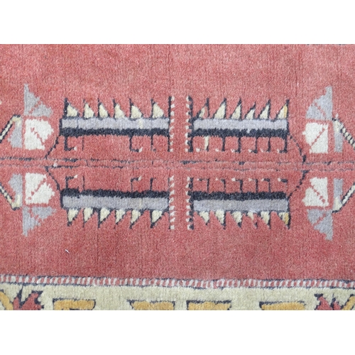 1345 - Carpet / Rug : A rug with salmon and cream grounds with geometric and floral detail and mustard bord... 