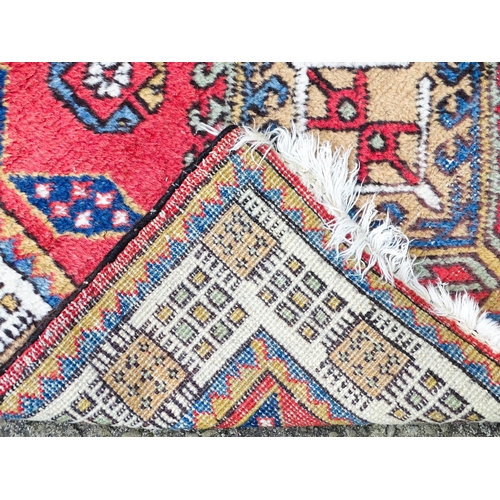 1347 - Carpet / Rug : A red ground runner decorated with central geometric motifs, floral details and geome... 