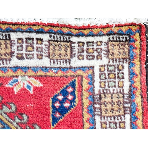 1347 - Carpet / Rug : A red ground runner decorated with central geometric motifs, floral details and geome... 