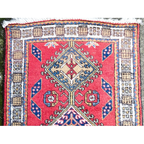 1347 - Carpet / Rug : A red ground runner decorated with central geometric motifs, floral details and geome... 