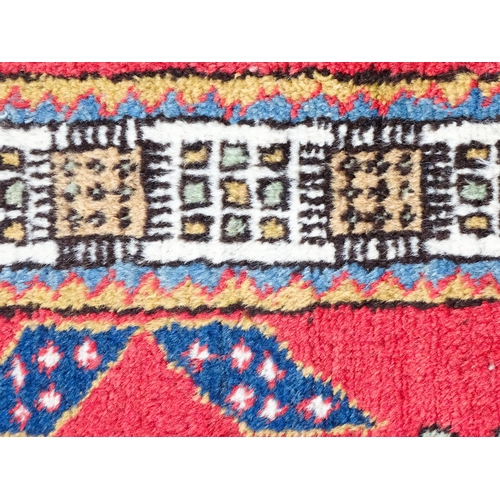 1347 - Carpet / Rug : A red ground runner decorated with central geometric motifs, floral details and geome... 