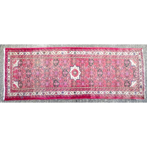 1349 - Carpet / Rug : A runner with pink red grounds decorated with floral foliate and geometric motifs  Ap... 