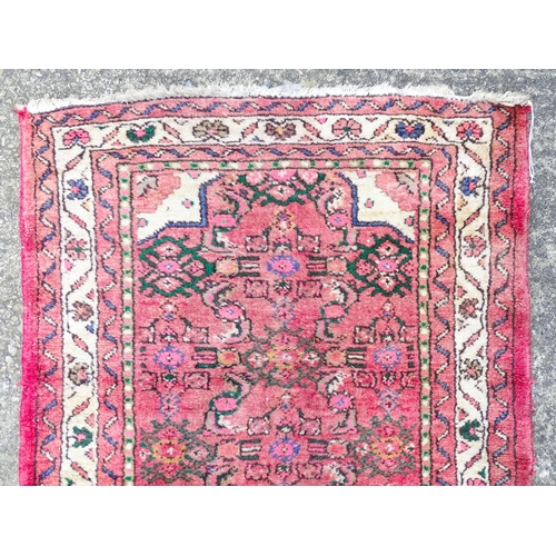 1349 - Carpet / Rug : A runner with pink red grounds decorated with floral foliate and geometric motifs  Ap... 