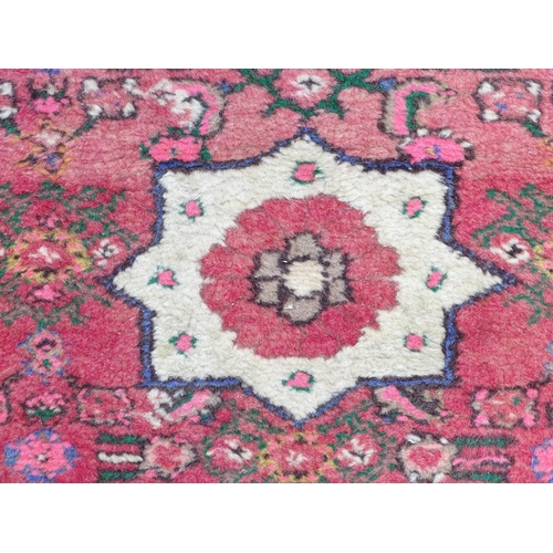 1349 - Carpet / Rug : A runner with pink red grounds decorated with floral foliate and geometric motifs  Ap... 