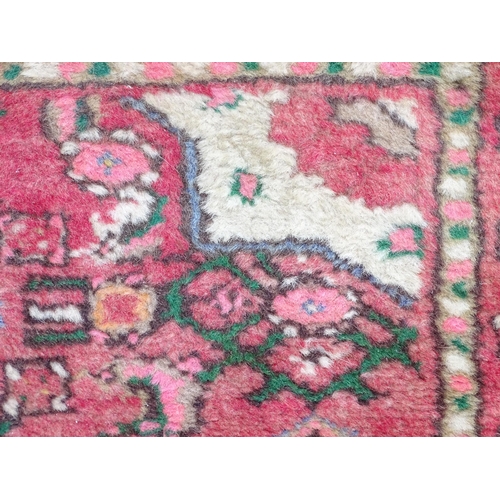 1349 - Carpet / Rug : A runner with pink red grounds decorated with floral foliate and geometric motifs  Ap... 