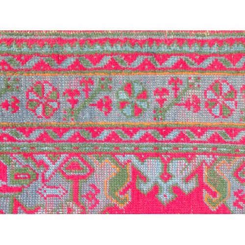 1350 - Carpet / Rug : A  red ground rug decorated with floral, foliate and geometric detail worked in blue ... 