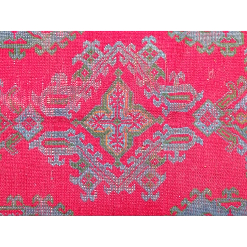 1350 - Carpet / Rug : A  red ground rug decorated with floral, foliate and geometric detail worked in blue ... 