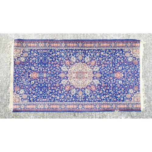 1351 - Carpet / Rug : A blue ground rug with central roundel motiff and floral and foliate detail. Approx. ... 