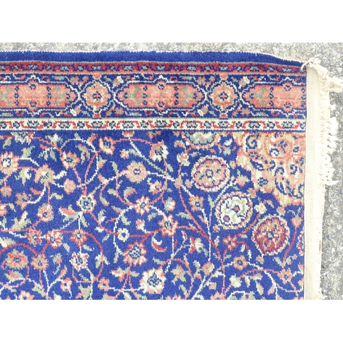 1351 - Carpet / Rug : A blue ground rug with central roundel motiff and floral and foliate detail. Approx. ... 