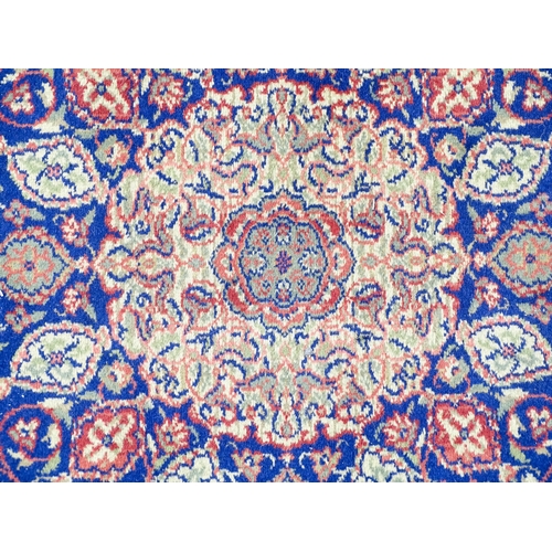 1351 - Carpet / Rug : A blue ground rug with central roundel motiff and floral and foliate detail. Approx. ... 