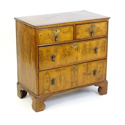 1450 - An 18thC walnut chest of drawers with a moulded and crossbanded top above two short over three long ... 