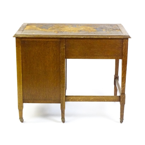 1478 - An Arts & Crafts oak desk, with an inset leather top above a bank of four graduated drawers and one ... 