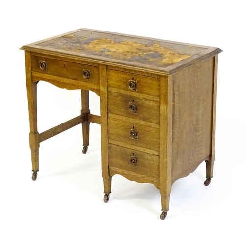 1478 - An Arts & Crafts oak desk, with an inset leather top above a bank of four graduated drawers and one ... 