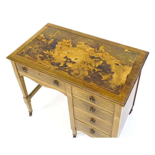 1478 - An Arts & Crafts oak desk, with an inset leather top above a bank of four graduated drawers and one ... 