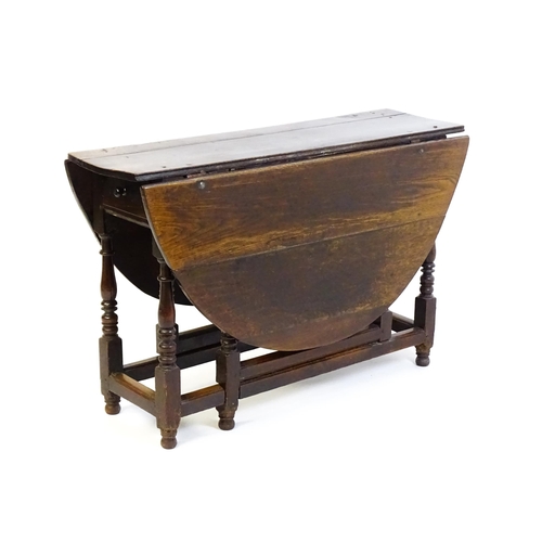 1484 - An early 18thC oak drop flap table, with two demi leaves and a short drawer to one end, the table ra... 