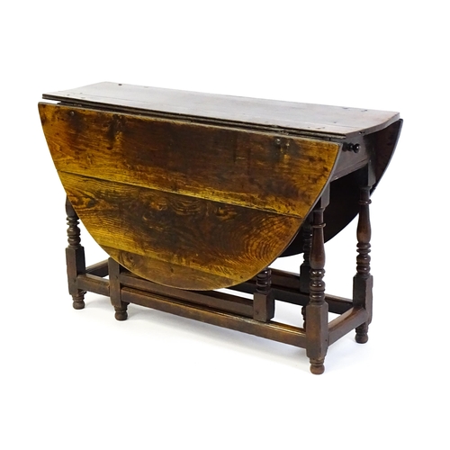 1484 - An early 18thC oak drop flap table, with two demi leaves and a short drawer to one end, the table ra... 