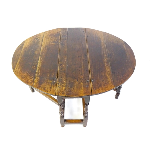 1484 - An early 18thC oak drop flap table, with two demi leaves and a short drawer to one end, the table ra... 