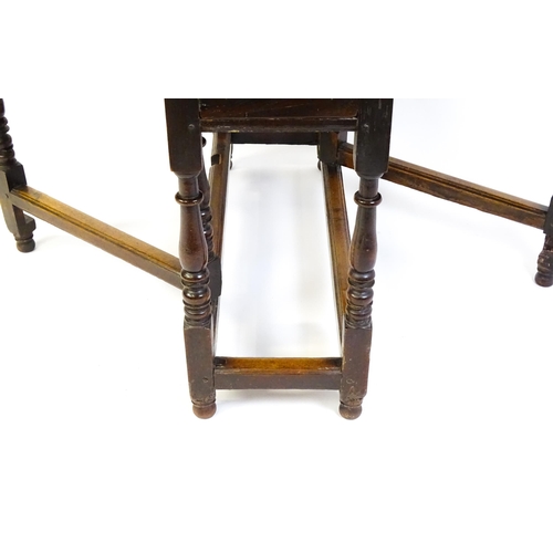 1484 - An early 18thC oak drop flap table, with two demi leaves and a short drawer to one end, the table ra... 