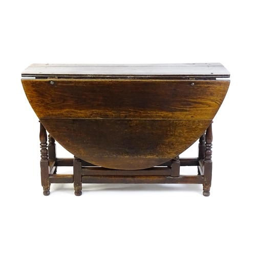 1484 - An early 18thC oak drop flap table, with two demi leaves and a short drawer to one end, the table ra... 