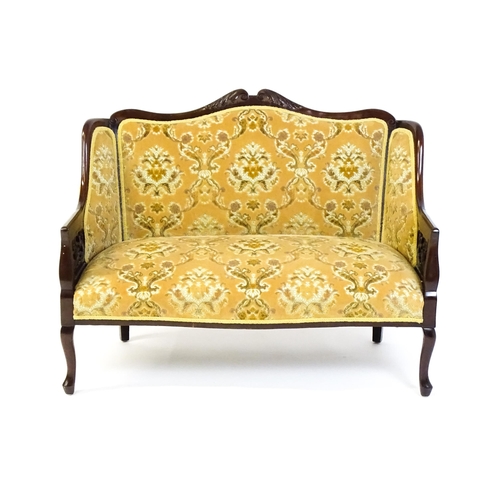 1486 - An early 20thC mahogany settee with a carved and shaped cresting rail above a sprung seat and pierce... 