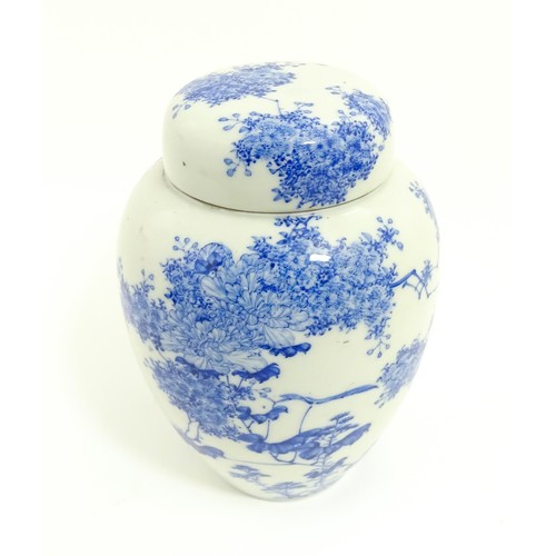 4 - A Japanese blue and white ginger jar / tea caddy decorated with flowers and foliage. Approx. 7 3/4