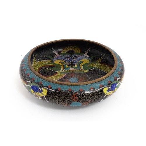 1058 - A Chinese cloisonne dish the black ground with dragon and flaming pearl decoration. Character marks ... 