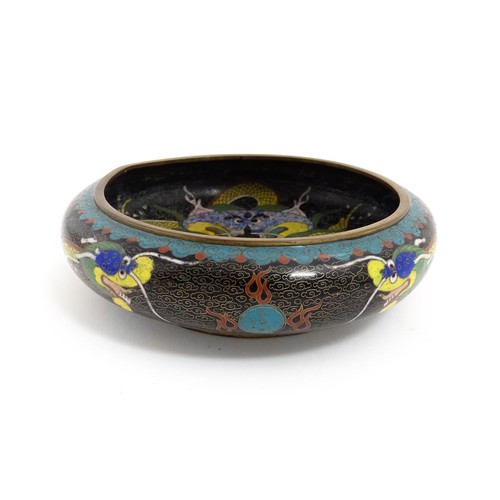 1058 - A Chinese cloisonne dish the black ground with dragon and flaming pearl decoration. Character marks ... 