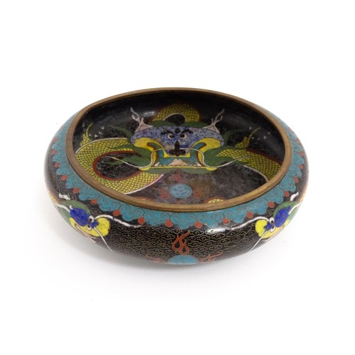 1058 - A Chinese cloisonne dish the black ground with dragon and flaming pearl decoration. Character marks ... 