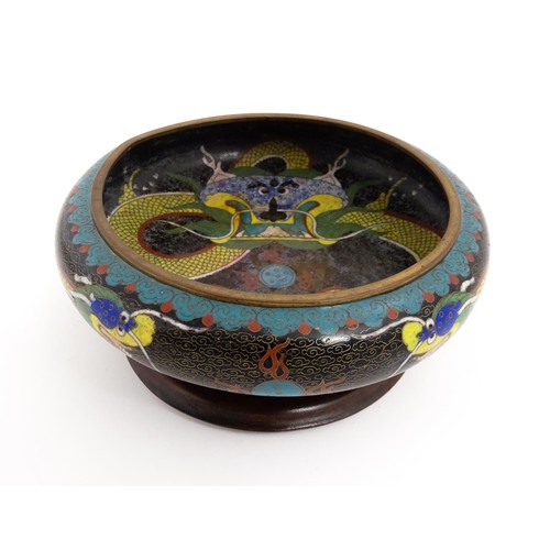 1058 - A Chinese cloisonne dish the black ground with dragon and flaming pearl decoration. Character marks ... 