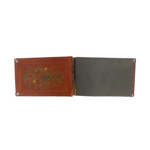 1114 - A Persian photograph album with lacquered boards decorated with a hand painted panel depicting a cou... 