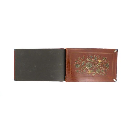 1114 - A Persian photograph album with lacquered boards decorated with a hand painted panel depicting a cou... 