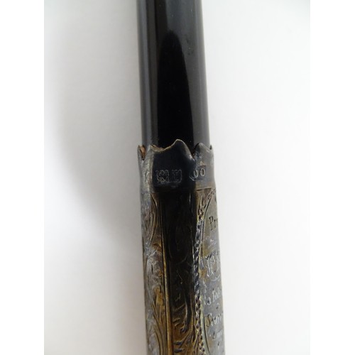 1118 - An early 20thC ebonised conductor's baton of tapering form with silver mounts engraved with foliate ... 