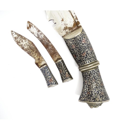 1128 - A Malaysian kukri knife, with engraved floral and foliate handle with lion mask detail to end. The r... 