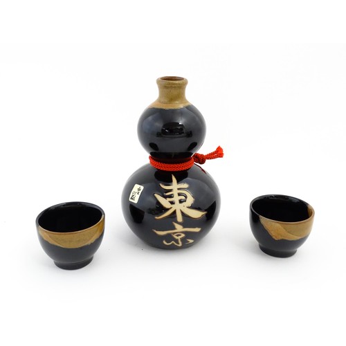 1146 - A boxed ceramic Saki decanter with two cups, together with a Keiryu Monde Selection Gold Award selec... 