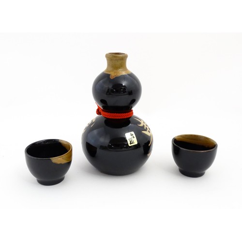 1146 - A boxed ceramic Saki decanter with two cups, together with a Keiryu Monde Selection Gold Award selec... 