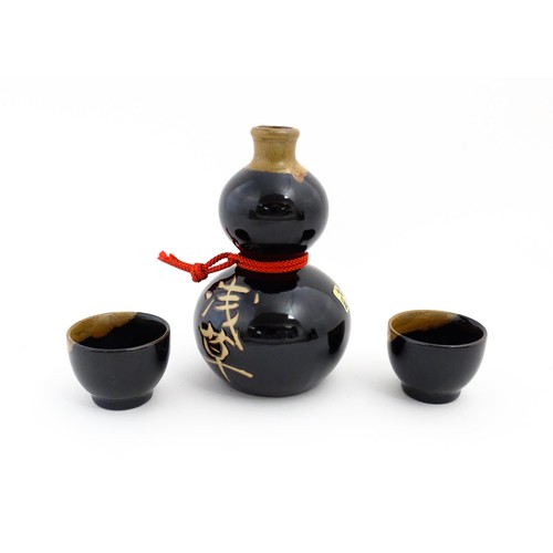 1146 - A boxed ceramic Saki decanter with two cups, together with a Keiryu Monde Selection Gold Award selec... 