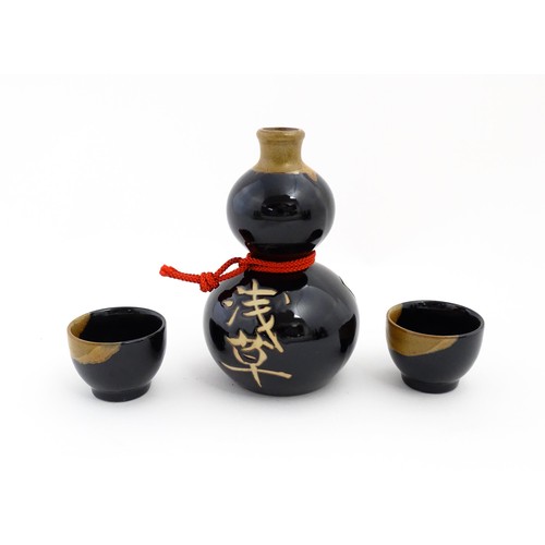 1146 - A boxed ceramic Saki decanter with two cups, together with a Keiryu Monde Selection Gold Award selec... 