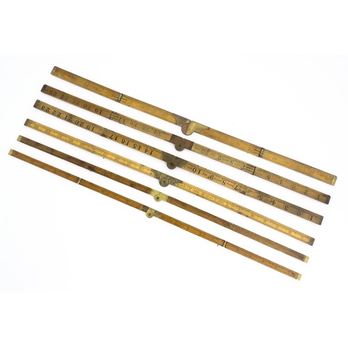 1202 - A quantity of 20thC boxwood and brass folding rulers to include examples by Rabone, Stanley Rule & L... 