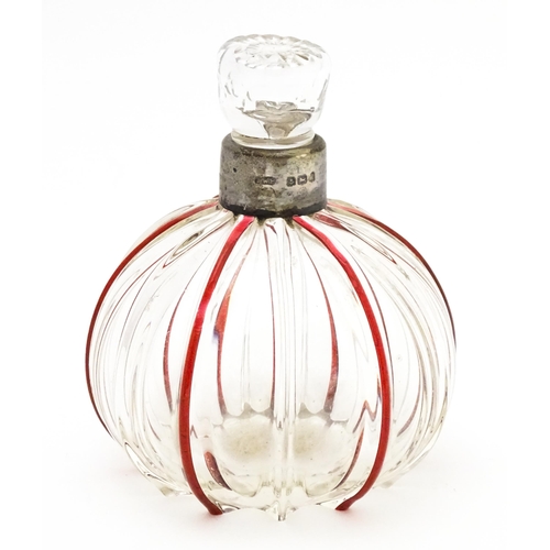 240 - An early 20thC glass scent / perfume bottle with red glass detail and silver collar hallmarked Birmi... 