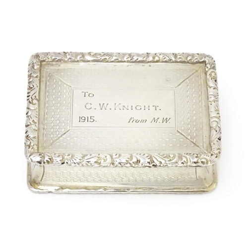 312 - A silver snuff box with waisted sides and engine turned decoration, opening to reveal a gilded inter... 