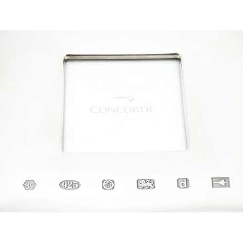 532 - Concord Memorabilia: An easel back photograph frame with silver surround hallmarked Sheffield 2003, ... 