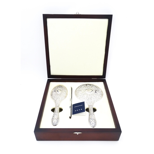 546 - A silver backed dressing table set comprising brush, comb and hand mirror, hallmarked Sheffield 2012... 