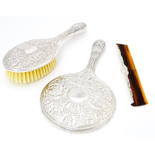 546 - A silver backed dressing table set comprising brush, comb and hand mirror, hallmarked Sheffield 2012... 