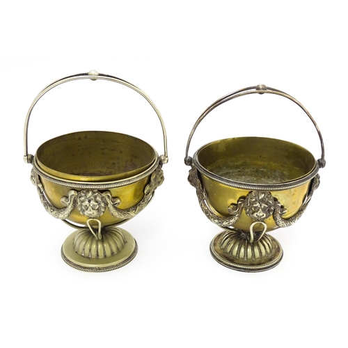 556 - A pair of brass and silver plate pedestal bowls with lions mask and swag detail and swing handles. A... 