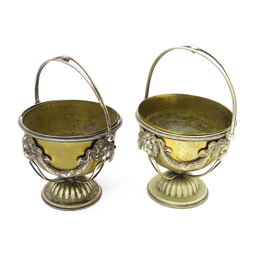 556 - A pair of brass and silver plate pedestal bowls with lions mask and swag detail and swing handles. A... 