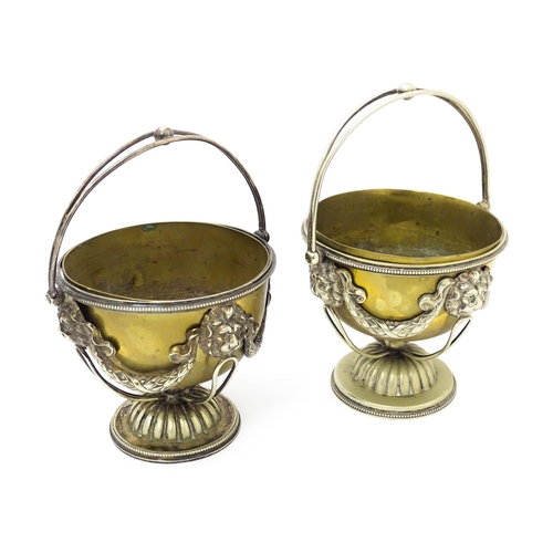 556 - A pair of brass and silver plate pedestal bowls with lions mask and swag detail and swing handles. A... 